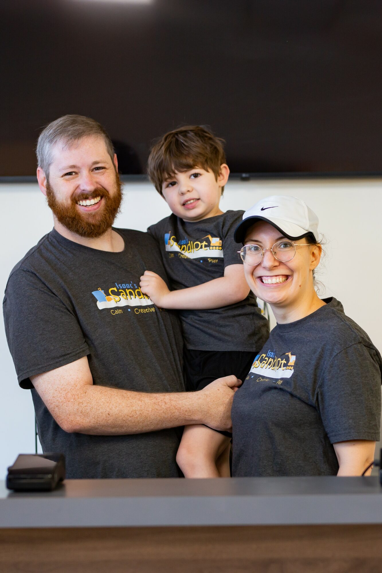Will, Isaac, and Valerie behind the front desk at Isaac's Sandlot